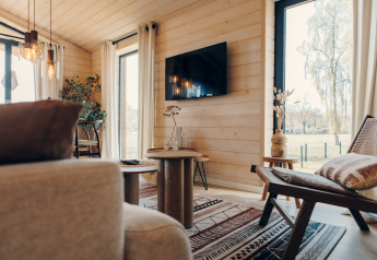 Stue i The Beach House på Wilsumer Berge, Tyskland, med trævægge, moderne møbler og stor udsigt.