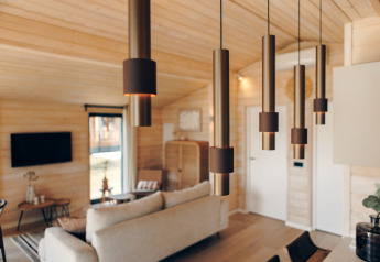 Moderne opholdsstue med trendy hængelamper, trævægge og hyggelig indretning i The Beach House, Wilsumer Berge.