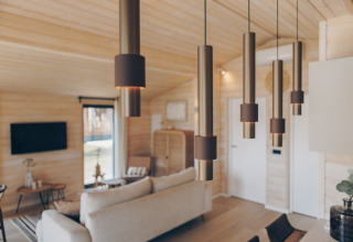 Salon moderne avec suspensions élégantes, murs en bois et ambiance chaleureuse à The Beach House, Wilsumer Berge.