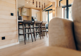 Lyst og moderne køkkenalrum med barstole og store vinduer på The Beach House i Wilsumer Berge, Tyskland.