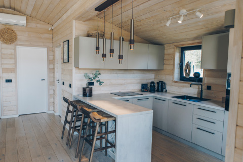 Modernes Kücheninterieur im Beach House in Wilsumer Berge, Deutschland, mit stilvollen Hängelampen und Barhockern.