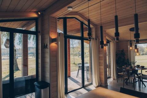 Vue intérieure de The Beach House à Wilsumer Berge, Allemagne, avec de grandes fenêtres et déco moderne.