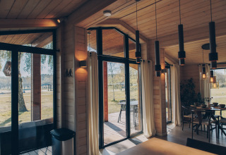 Innenansicht des Beach House in Wilsumer Berge, Deutschland, mit großen Fenstern und moderner Einrichtung.