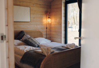 Hyggeligt soveværelse i The Beach House på Wilsumer Berge, Tyskland, med moderne trædesign.