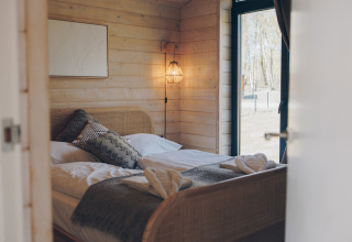 Gemütliches Schlafzimmer im The Beach House im Wilsumer Berge, Deutschland, mit Holzverkleidung.