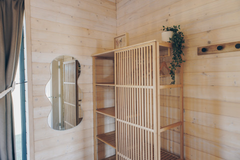 Innenaufnahme eines holzverkleideten Zimmers im The Beach House in Wilsumer Berge, Deutschland, mit Spiegel.