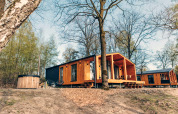 Chalets en bois au Hill Side Scandi lodge à Wilsumer Berge en Allemagne, entourés de forêt.