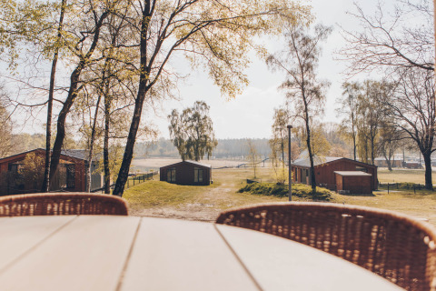 Uitzicht vanaf het terras bij Hill Side Scandi lodge op Wilsumer Berge, Duitsland, met huisjes.