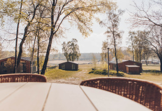 Uitzicht vanaf het terras bij Hill Side Scandi lodge op Wilsumer Berge, Duitsland, met huisjes.