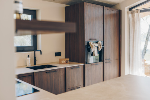 Moderne keuken met houten kasten in de Hill Side Scandi lodge in Wilsumer Berge, Duitsland.