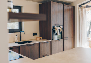Moderne keuken met houten kasten in de Hill Side Scandi lodge in Wilsumer Berge, Duitsland.