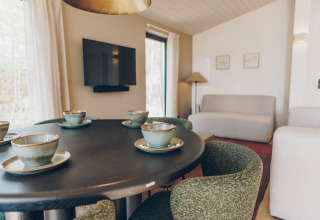 Moderne woonkamer in Hill Side Scandi lodge bij Wilsumer Berge, Duitsland, gedekt voor vier personen.