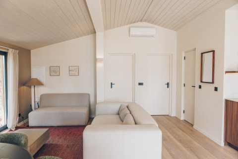 Moderne, Scandinavisch ingerichte lodge-woonkamer met lichte muren bij Wilsumer Berge in Duitsland.