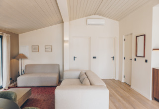 Moderne, Scandinavisch ingerichte lodge-woonkamer met lichte muren bij Wilsumer Berge in Duitsland.
