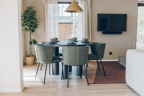 Moderne eethoek in de Hill Side Scandi lodge bij Wilsumer Berge, Duitsland, met vier stoelen en servies.