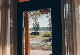 Uitzicht vanuit de Hill Side Scandi lodge bij Wilsumer Berge in Duitsland, met hut en meer op de achtergrond.