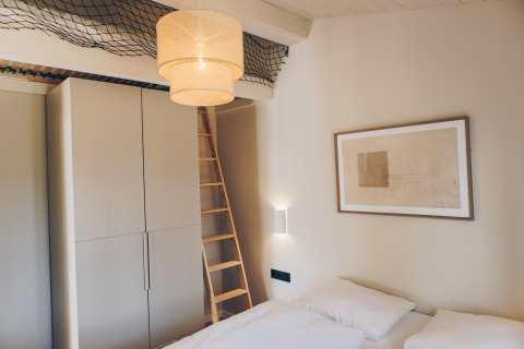 Moderne slaapkamer in Hill Side Scandi, Wilsumer Berge, Duitsland, met ladder en wanddecoratie.