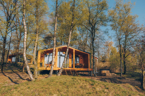 Beach Side Scandi lodge nestled among trees with a hot tub, set in a tranquil forest retreat.