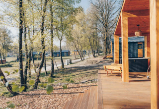 Outdoor view from the Beach Side Scandi lodge at Wilsumer Berge, Germany, with terrace and trees.