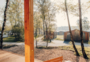 Blick von der Beach Side Scandi-Lodge in Wilsumer Berge auf moderne Hütten, Bäume und Wege in Deutschland.