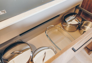 Drawer with pots and glass baking dish in the kitchen at Beach Side Scandi lodge, Wilsumer Berge, Germany.