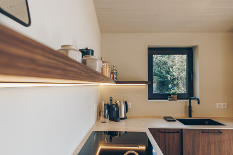 Modern Scandinavian kitchen at Beach Side Scandi lodge, Wilsumer Berge, Germany, with wooden shelving.