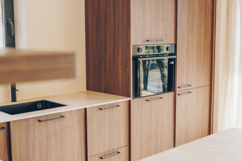 Bright modern kitchen at Beach Side Scandi lodge in Wilsumer Berge, Germany, with built-in oven and wood cabinets.