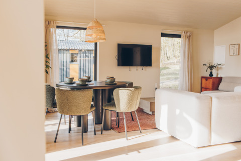 Bright, modern living area in the Beach Side Scandi lodge at Wilsumer Berge, Germany, with dining table.