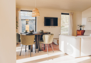 Bright, modern living area in the Beach Side Scandi lodge at Wilsumer Berge, Germany, with dining table.