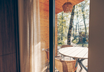 Blick aus der Beach Side Scandi-Lodge in Wilsumer Berge, Deutschland mit Holzmöbeln und Waldblick.