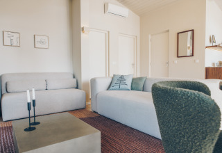 Modern living room in Beach Side Scandi lodge at Wilsumer Berge, Germany, with bright, minimalist decor and furniture.