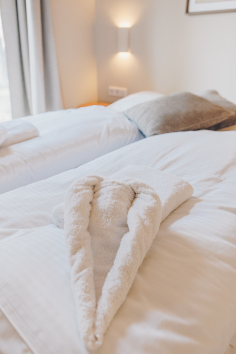 Room at Beach Side Scandi in Wilsumer Berge, Germany, with a heart-shaped towel arranged on the bed.