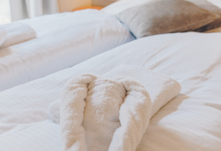 Room at Beach Side Scandi in Wilsumer Berge, Germany, with a heart-shaped towel arranged on the bed.