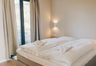 Bright bedroom with double bed, soft duvets, and window at Beach Side Scandi, Wilsumer Berge, Germany.