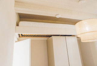 Modern loft bed at Beach Side Scandi lodge, Wilsumer Berge, Germany, featuring minimalist decor.