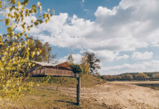 Uitzicht op de Glamfield Lodge premium safaritent bij het meer van Wilsumer Berge, Duitsland, op een zonnige dag.
