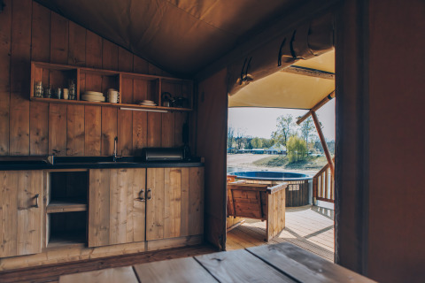 Binnenzicht van de Glamfield Lodge Premium safaritent bij Wilsumer Berge, Duitsland, met keuken en terras.