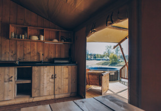 Binnenzicht van de Glamfield Lodge Premium safaritent bij Wilsumer Berge, Duitsland, met keuken en terras.