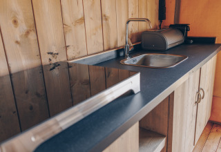 Keukenblad in safaritent 'Glamfield Lodge' Premium bij Wilsumer Berge in Duitsland, met spoelbak en kastjes.