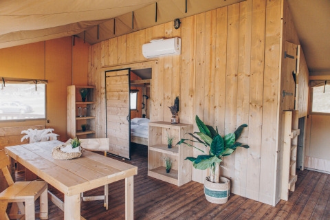 Interieur van safaritent ‘Glamfield Lodge’ Premium bij Wilsumer Berge in Duitsland met houten meubels.