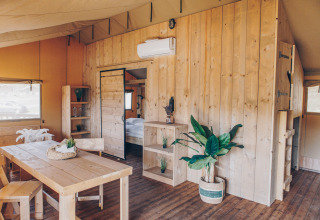 Interieur van safaritent ‘Glamfield Lodge’ Premium bij Wilsumer Berge in Duitsland met houten meubels.