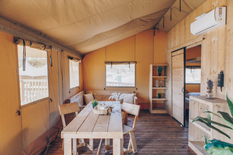 Binnenkant van safaritent ‘Glamfield Lodge’ Premium bij Wilsumer Berge in Duitsland met houten meubels.