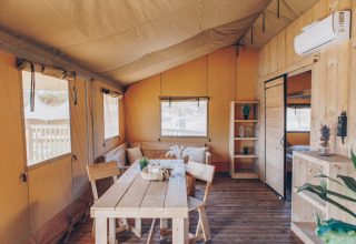 Binnenkant van safaritent ‘Glamfield Lodge’ Premium bij Wilsumer Berge in Duitsland met houten meubels.