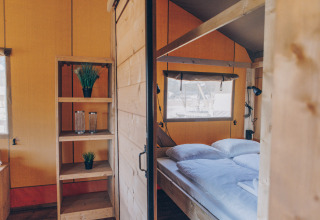 Interieur van een comfortabele slaapkamer in de 'Glamfield Lodge' Premium safaritent bij Wilsumer Berge, Duitsland.
