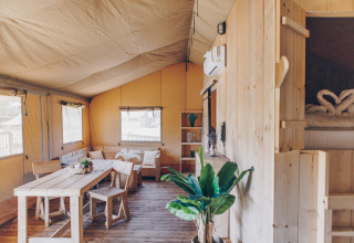 Interieur van de Glamfield Lodge premium safaritent met houten meubels en planten, Wilsumer Berge, Duitsland.