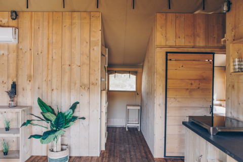 Interieur van de Glamfield Lodge Premium safaritent op Wilsumer Berge in Duitsland met houten panelen.