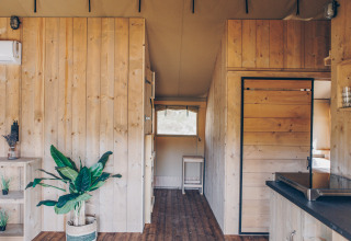 Interieur van de Glamfield Lodge Premium safaritent op Wilsumer Berge in Duitsland met houten panelen.