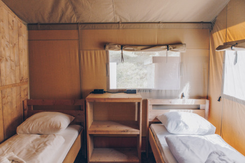 Twee eenpersoonsbedden in een safaritent bij Glamfield Lodge Premium, Wilsumer Berge, met houten interieur.