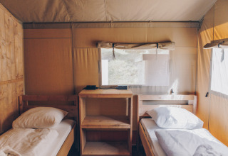 Twee eenpersoonsbedden in een safaritent bij Glamfield Lodge Premium, Wilsumer Berge, met houten interieur.