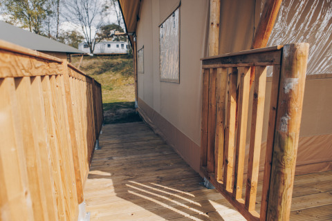 Houten terras en oprit bij Glamfield Lodge Premium safaritent op Wilsumer Berge in Duitsland, zonnige dag.